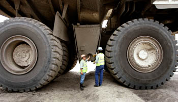 Two Colombian miners inspect a mining truck at the Cerrejon coal mine (Reuters/Jose Miguel Gomez)