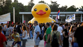 Protesters walk past a rubber duck, the symbol of protest against the Belgrade Waterfront project, on June 25 (Reuters/Djordje Kojadinovic)