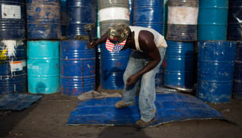 A man beats a sheet of metal cut from an oil barrel in Kamukunji, Nairobi (Reuters/Siegfried Modola)