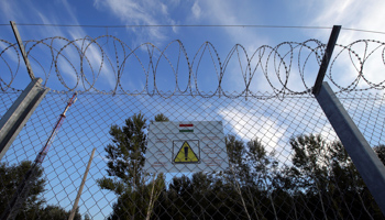 A sign warns refugees at the border fence on the Hungary-Serbia borderline (Reuters/Laszlo Balogh)