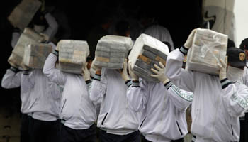 Police officers carry packages containing seized cocaine in Lima (Reuters/Enrique Castro-Mendivil)