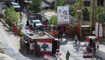 People walk past a Lebanese army checkpoint at the entrance to Ain al-Hilweh camp Palestinian refugee camp near Sidon, South Lebanon (Reuters/Ali Hashisho)