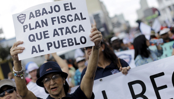 A woman holds a sign, which reads: "Down with the fiscal plan that is against the people", during a march in San Jose (Reuters/Juan Carlos Ulate)