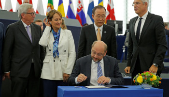 European Parliament President Martin Schulz, centre, signs the Paris Agreement (Reuters/Vincent Kessler)