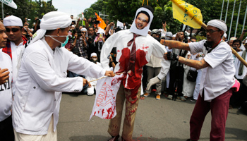 Members of the Islamic Defenders Front stab an effigy of Ahok at a protest rally in Jakarta (Reuters/Beawiharta)