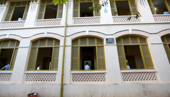 Invigilators stand near a window as students sit their examinations at a High School in Phnom Penh (Reuters/Samrang Pring)