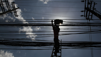 A worker installs internet cables near electric posts in Manila (Reuters/Romeo Ranoco)