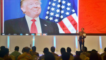 Indonesian President Joko Widodo speaks to local company executives with an image of Trump on a screen behind him at the Kompas CEO Forum 2016, Indonesia (Reuters/Antara Foto/Yudhi Mahatma)