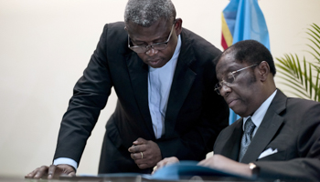 Congolese Justice Minister Alexis Thambwe Mwamba, right, signs the accord between the opposition and the government in Kinshasa (Reuters/Robert Carrubba)