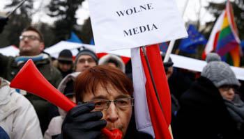 Demonstrators gather outside the Parliament building during a protest in Warsaw on December 17, with placards reading "Free Media!" (Reuters/Kacper Pempel)