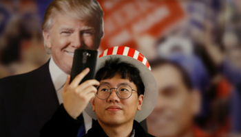 A man takes a selfie with a cut-out of Donald Trump (Reuters/Kim Hong)