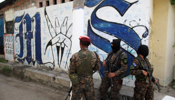 Soldiers stand guard next to a Mara Salvatrucha gang related graffiti in a neighborhood in Soyapango (Reuters/Jose Cabezas)