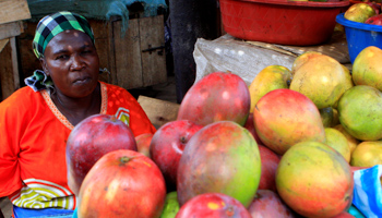 A woman sells fruits in a market in Kasese (Reuters/James Akena)