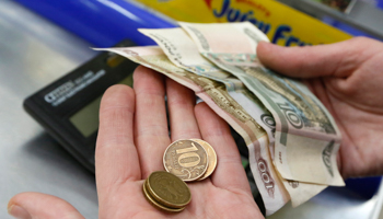 A shop assistant counts money at a grocery in Krasnoyarsk (Reuters/Ilya Naymushin)