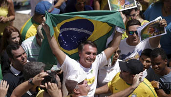 Right-wing Congressman Jair Bolsonaro holding a Brazilian flag (Reuters/Ueslei Marcelino)