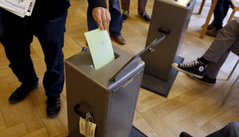 People cast their vote in a school house in Bern, Switzerland (Reuters/Ruben Sprich)