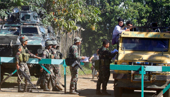 Soldiers distribute pictures of an extremist group member, at a checkpoint in Butig (Reuters/Marconi B. Navales)