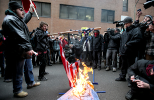 Protesters burn the US flag and an effigy of President Donald Trump in front of the US Consulate General in Montreal (Reuters/Christinne Muschi)