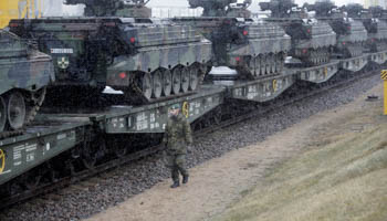 A German army soldier walks past Marder infantry fighting vehicles at the railway station in Sestokai, Lithuania (Reuters/Ints Kalnins)