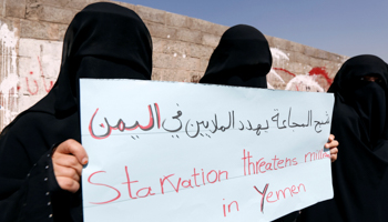 Women protesters, marking the International Women's Day hold signs saying 'Starvation threatens millions in Yemen’,outside the United Nations offices in Sanaa, Yemen (Reuters/Khaled Abdullah)