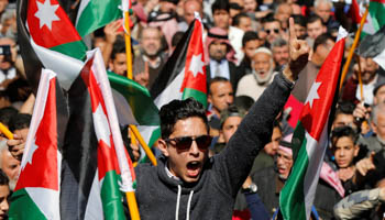 Protesters hold Jordanian national flags and chant slogans during a protest against rising prices and taxes, in Amman, Jordan (Reuters/Muhammad Hamed)