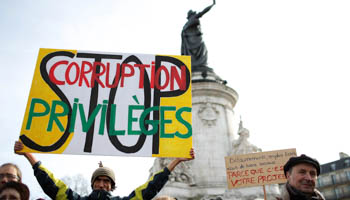 A man holds a banner at a demonstration in Paris against corrupt elected representatives, February 25, 2017 (Reuters/Gonzalo Fuentes)