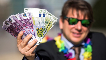 An activist shows fake banknotes during a demonstration outside the European Commission headquarters, in Brussels, Belgium (Reuters/Yves Herman)