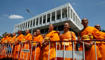 Buddhist monks gather outside Khlongluang provincial police station to show support for Phra Dhammachayo (Reuters/Chaiwat Subprasom)