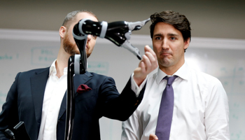 Canadian Prime Minister Justin Trudeau, right, operates a robotic arm at Kinova Robotics in Boisbriand, Quebec (Reuters/Christinne Muschi)
