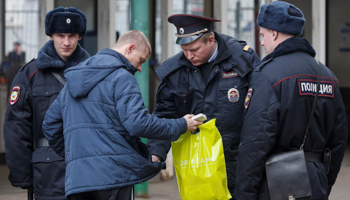 Police officers check a pedestrian's belongings following the St Petersburg metro blast that took place on April 3, Moscow (Reuters/Maxim Shemetov)