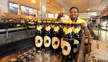 A worker checks beer bottles on a conveyor belt at the East African Breweries Ruaraka factory in Nairobi (Reuters/Thomas Mukoya)