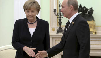 Putin (R) approaches to shake hands with Merkel during a meeting at the Kremlin in Moscow (Reuters/Sergei Karpukhin)