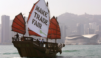 A junk carrying a banner from international relief group Oxfam sails past the Hong Kong Convention and Exhibition Centre (Reuters/Bobby Yip)