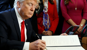 President Donald Trump signs a presidential statement on rolling back regulations from the 2010 Dodd-Frank law (Reuters/Kevin Lamarque)