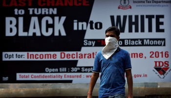 A man walks pasts an income tax billboard in Delhi (Reuters/Adnan Abidi)