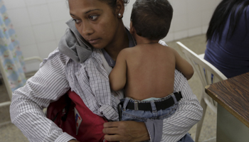 A mother and child with suspected Zika wait in a hospital emergency room (Reuters/Marco Bello)