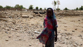 A girl stands outside ruined homes in front of an IDP camp in Borno (Reuters/Afolabi Sotunde)