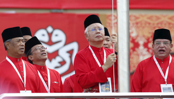 Malaysia's Prime Minister Najib Razak, centre, raises the UMNO flag during the annual assembly at the Putra World Trade Centre in Kuala Lumpur, Malaysia in 2015 (Reuters/Olivia Harris)