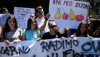 Schoolchildren hold placards reading, "Are we really doing this in the 21st century?" and "We can do it together" at a protest against ethnic segregation in Travnik, BiH, June 20 (Reuters/Dado Ruvic)