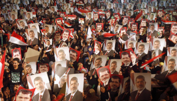 Members of the Muslim Brotherhood and supporters of Egypt's President Mohamed Mursi hold pictures of him at the Raba El-Adwyia mosque square in Cairo July in 2013 (Reuters/Khaled Abdullah)