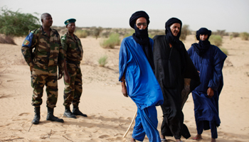 Malian soldiers stand next to Tuareg men near Timbuktu (Reuters/Joe Penney)