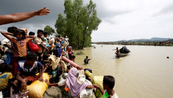 Rohingya refugees wait for a boat to cross a canal after crossing the border into Bangladesh (Reuters/Mohammad Ponir Hossain)