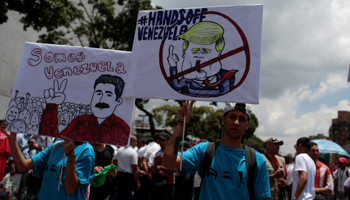 Government supporters with signs reading "We are Venezuela" and "Hands Off Venezuela" (Reuters/Marco Bello)