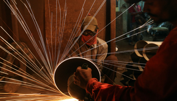 A worker inside a workshop manufacturing metal pipes in Mumbai (Reuters/Shailesh Andrade)