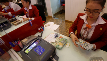 Women count money at a bank in Ho Chi Minh City, Vietnam, January 10, 2017. (Reuters/Kham)