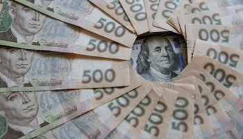 Ukrainian 500 hryvnia banknotes and a US 100 dollar banknote (Reuters/Valentyn Ogirenko/Illustration)
