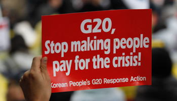 A demonstrator holds up a sign during an anti G20 protest in downtown Seoul (Reuters/Jo Yong-Hak)