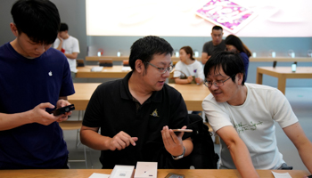 A customer holds his new iPhone 8 Plus after it goes on sale at an Apple Store in Shanghai, China (Reuters/Aly Song)