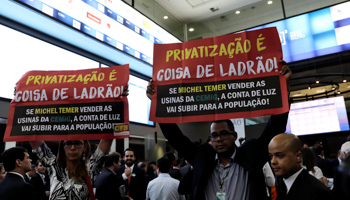 Protesters with signs reading "privatisation is for thieves" demonstrate against the auction of four hydroelectric dams (Reuters/Paulo Whitaker)