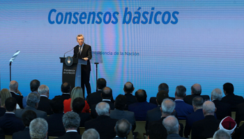 President Mauricio Macri announces economic reforms in front of a screen reading “Basic consensus” (Reuters/Marcos Brindicci)